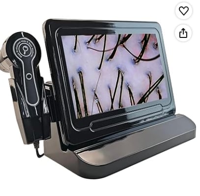 Digital microscope with tablet display showing magnified hair follicles and handheld probe on stand